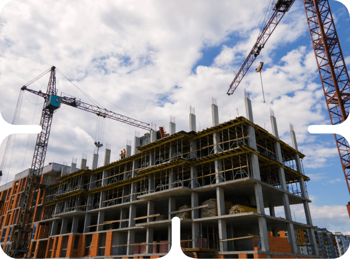 High-rise building under construction with cranes and concrete framework at a construction site